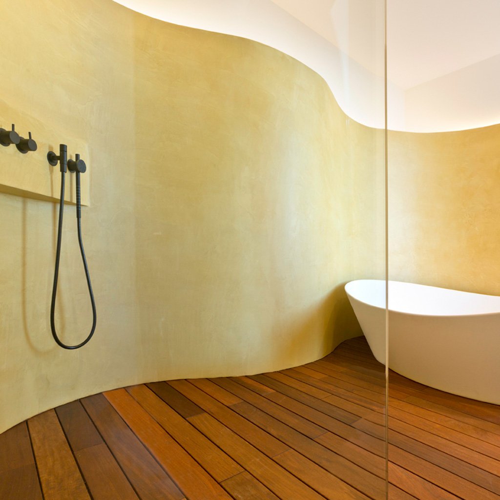 In this image you can appreciate a design example, in this case it is the en suite bathroom in a large villa, featuring a combination of materials and curved shapes that add elegance and functionality.